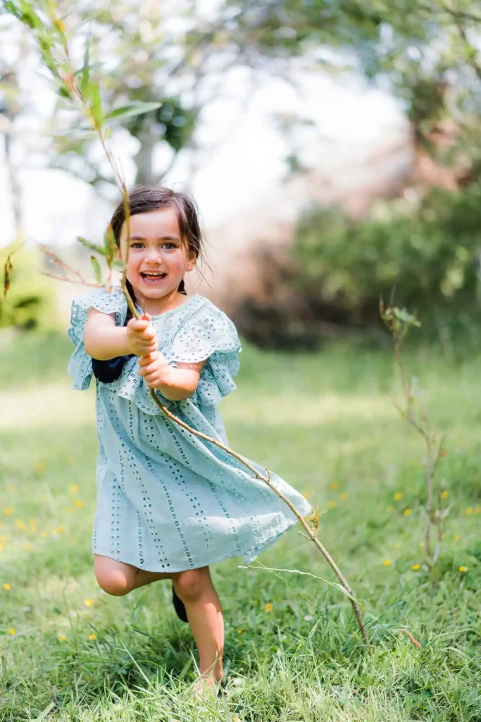 A happy child playing with a stuck in this stunning lifestyle portraits by Binh Trinh