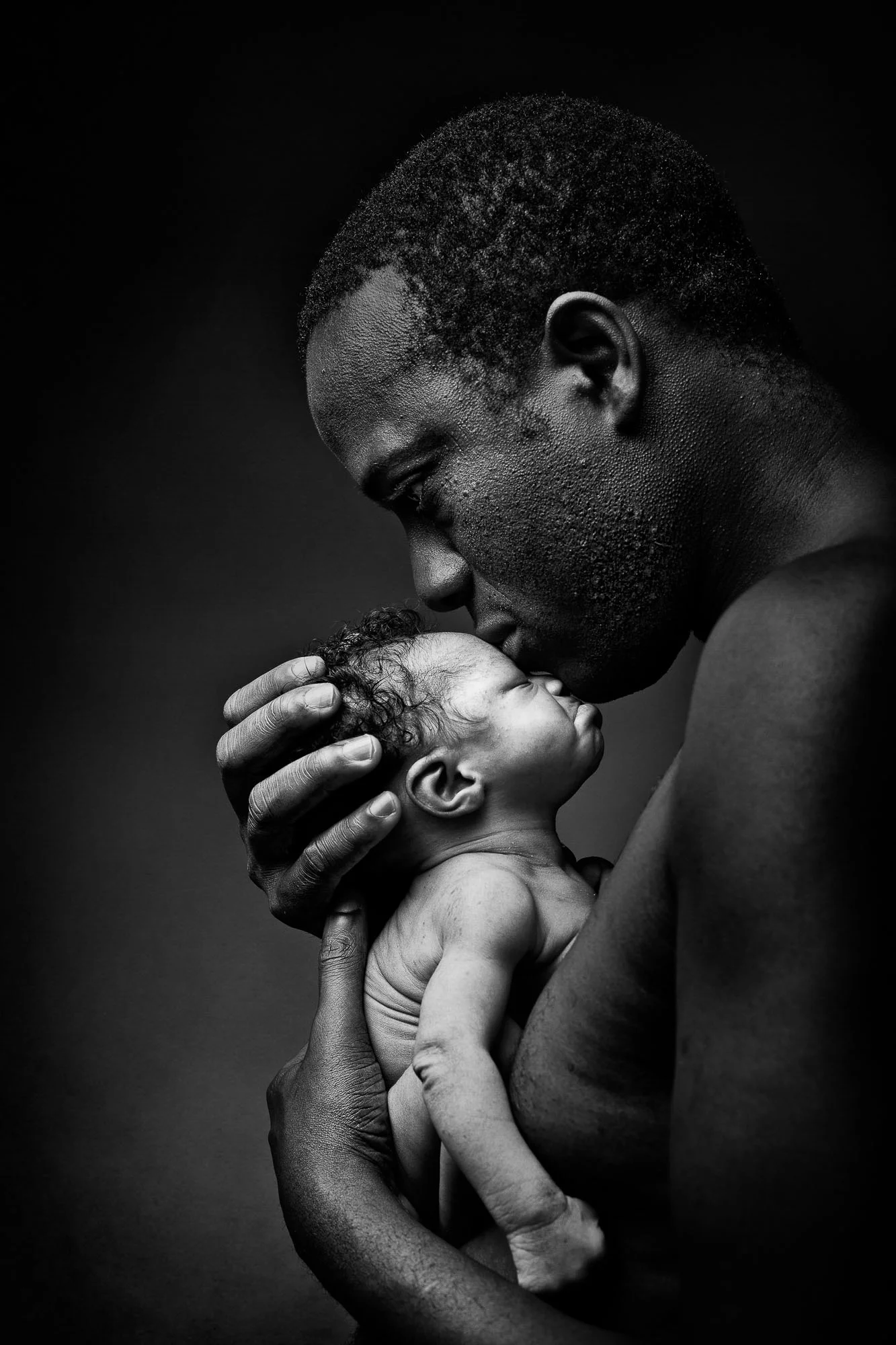 Father holding his newborn, black and white portrait
