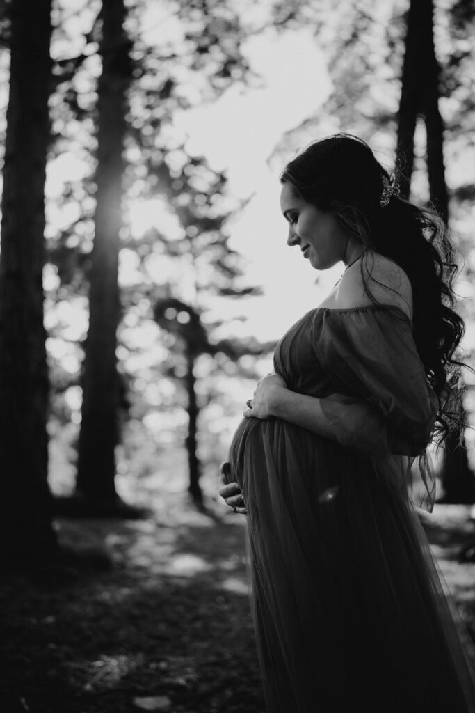 Maternity silhouette among trees, black and white