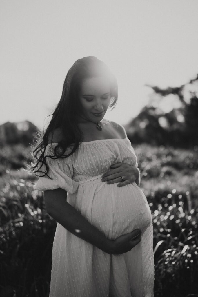 Expectant mother outdoors, black and white