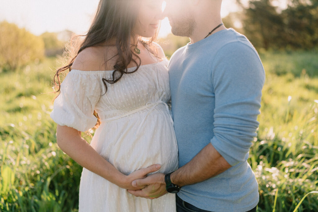 Expectant couple together at golden hour