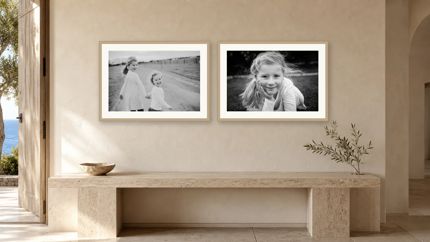 Two black and white portraits of children above a travertine entry bench
