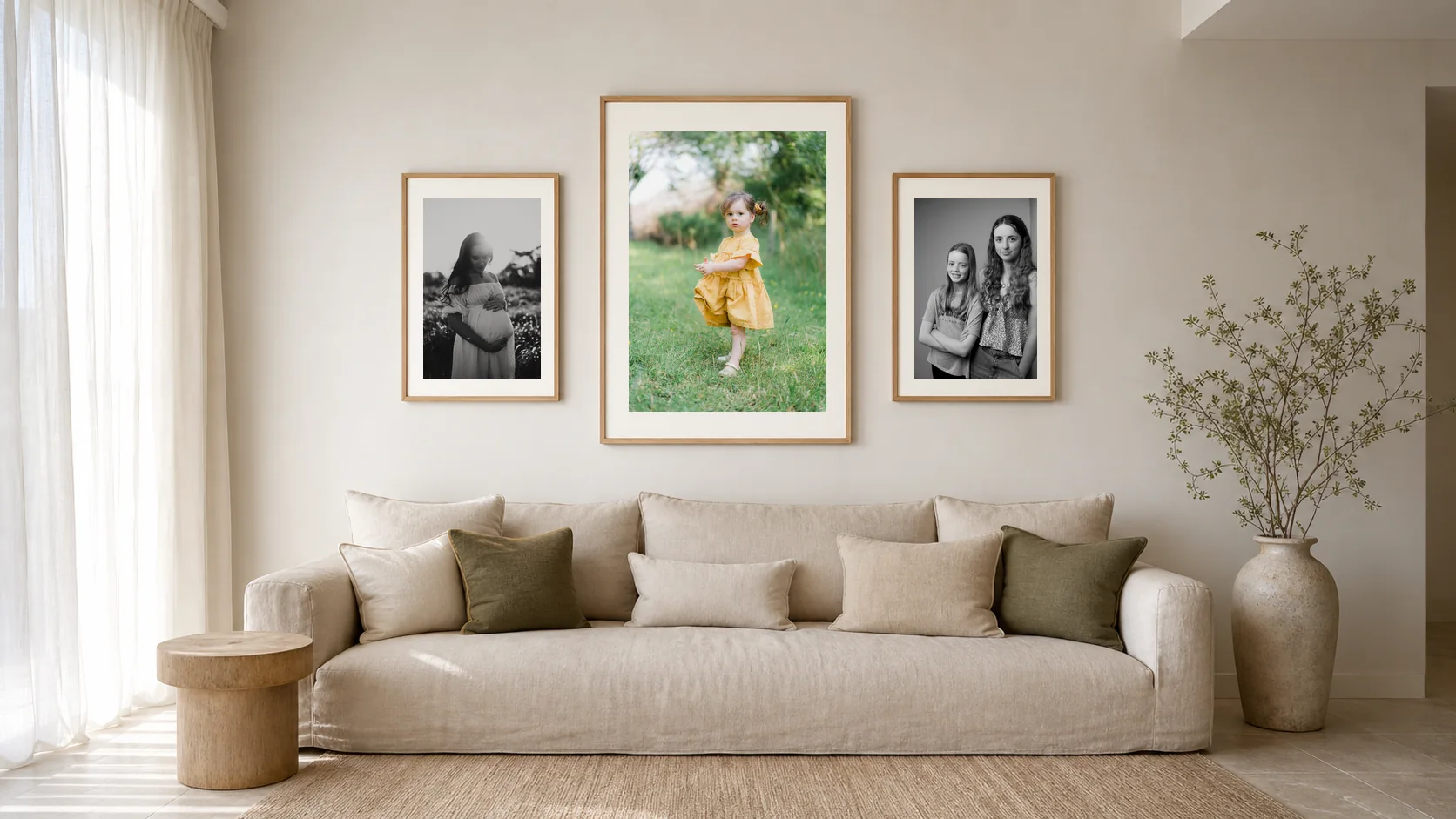 Three framed portraits above a linen lounge sofa