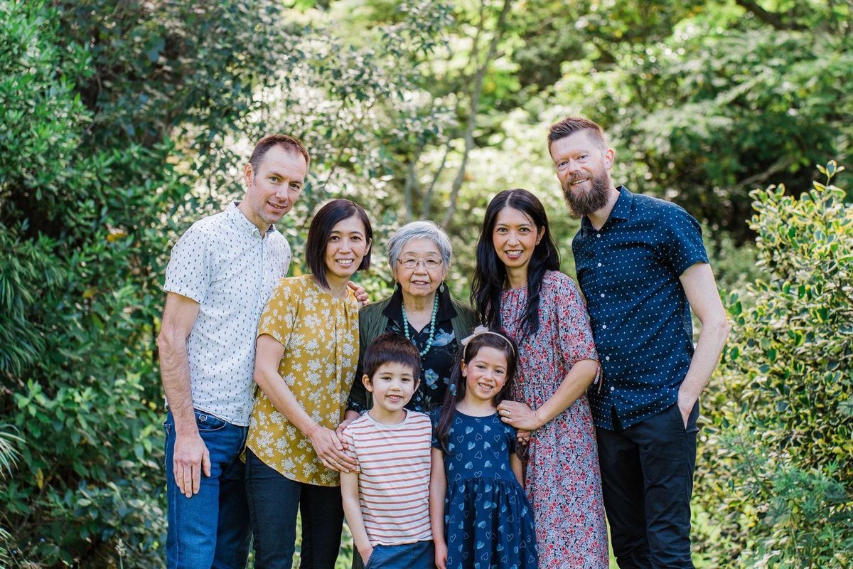 Three generations of a family in a leafy garden